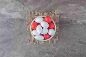 Free photo a bowl of candy on the trivet on the marble surface