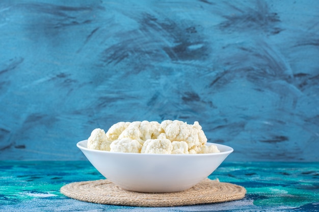 A bowl of cauliflower on a trivet 