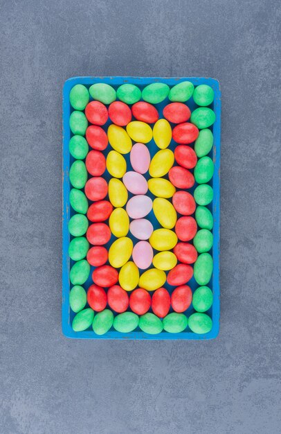 A bowl of colorful gums , on the marble background. 