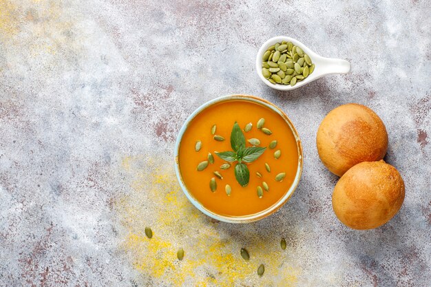 Bowl of delicious pumpkin soup with seeds.