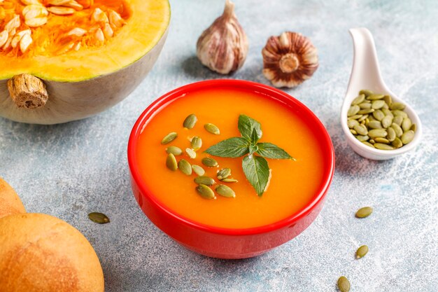 Bowl of delicious pumpkin soup with seeds.