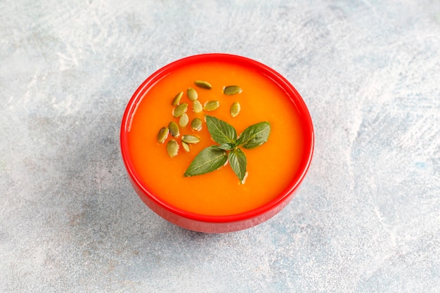 Bowl of delicious pumpkin soup with seeds.