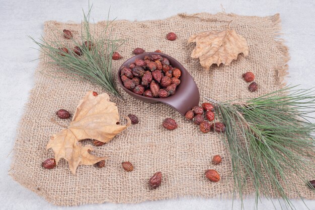 Bowl of dried cranberries and leaf on burlap. High quality photo