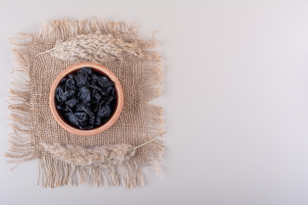 Bowl of dried plum fruits placed on white background. High quality photo