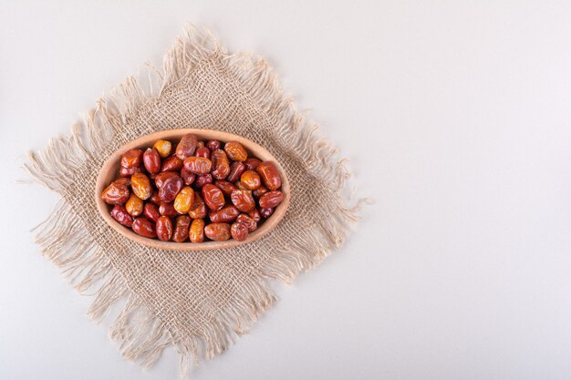 Bowl of dried tasty silverberry fruits on white background. High quality photo