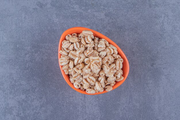 A bowl of dry cornflakes , on the blue background. High quality photo