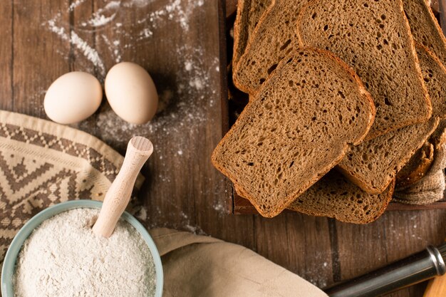 A bowl of flour with eggs and slices of bread