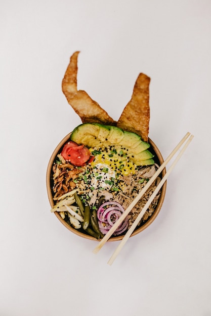 Free photo bowl of food with chopsticks