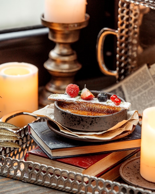 Миска французского десерта, украшенная ягодами, помещенная в книгу