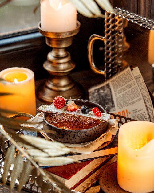 A bowl of french dessert garnished with long cookie and berries