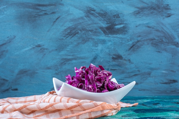 A bowl of fresh red cabbage on a tea towel