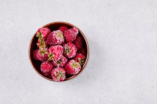 흰색 바탕에 신선한 빨간 나무 딸기의 그릇입니다.