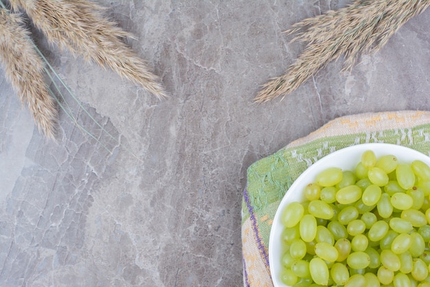 Bowl of green grapes on colorful tablecloth. 