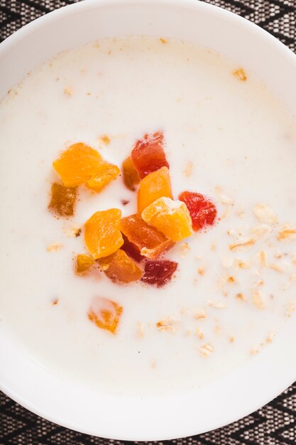 Bowl of healthy oatmeal with slices of fruits topping