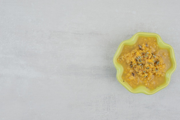 Bowl of homemade soup on white surface.