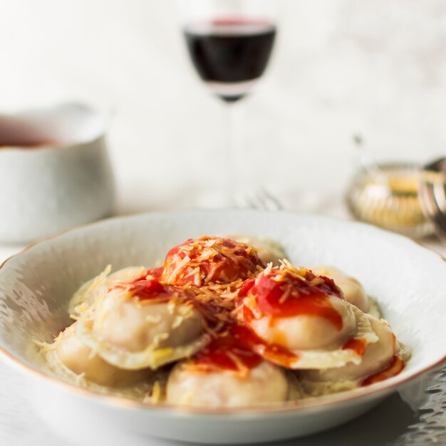 Bowl of italian ravioli pasta with spicy tomato sauce and cheese