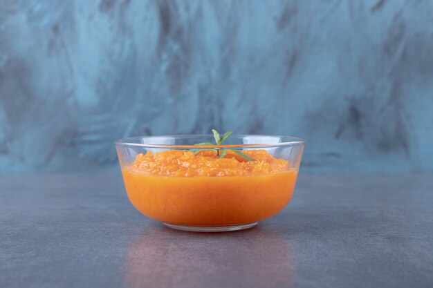 A bowl of lentil soup, on the marble surface.