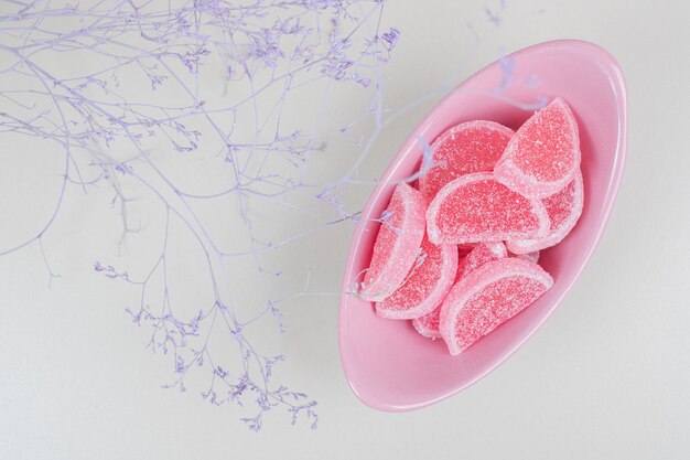 Bowl of marmalade candies on beige surface