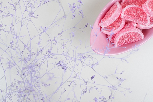 Free photo bowl of marmalade candies on beige surface