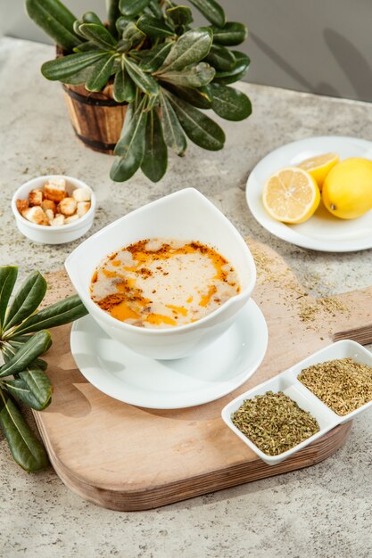 bowl of meat soup served with dried herbs and lemon