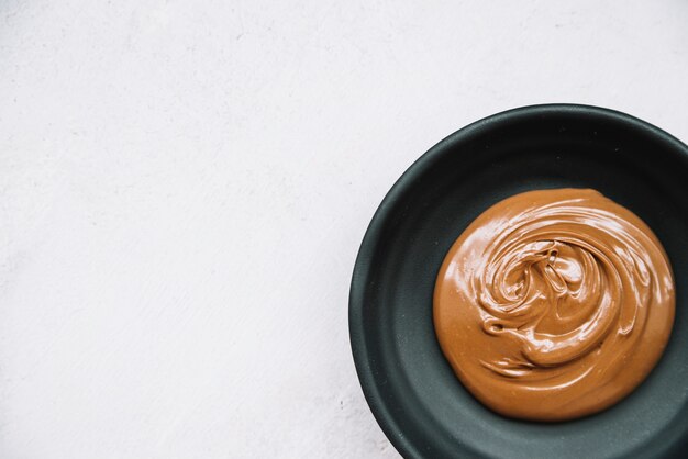 Bowl of melted chocolate in the bowl over white backdrop