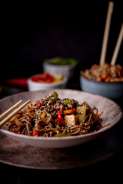 Bowl of noodles with sesame seeds and vegetables