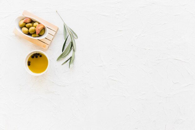 Bowl of olive with black pepper oil and twig