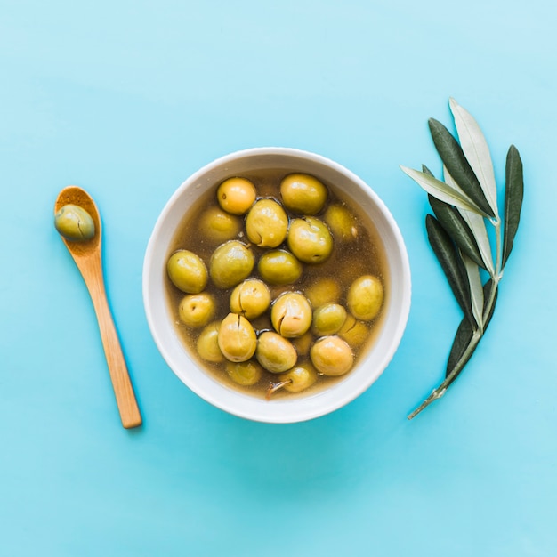 Free photo bowl of olives on blue background