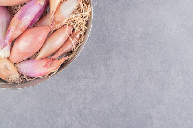 A bowl of onions on the marble surface