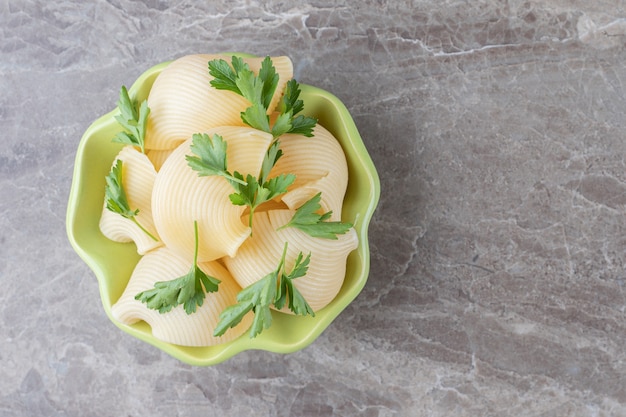 Foto gratuita una ciotola di pasta con verdure, sulla superficie di marmo.