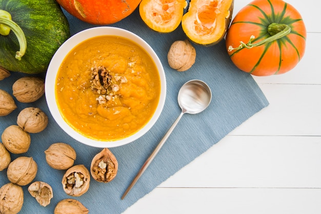 Bowl of pumpkin puree with walnuts on table