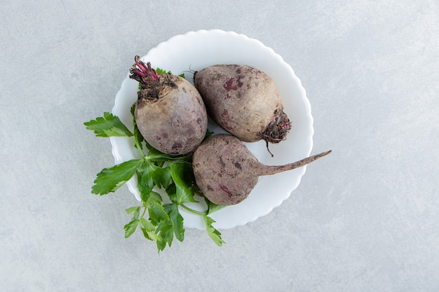 Free photo a bowl of radishes with parsley , on the marble background.