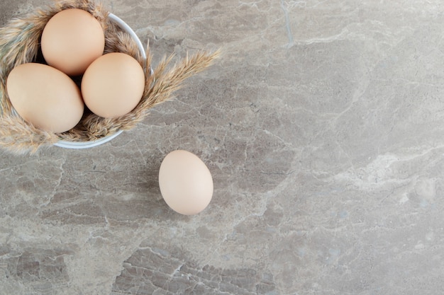 Free photo bowl of raw eggs on marble surface