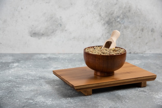 Free photo bowl of raw split peas placed on wooden board.