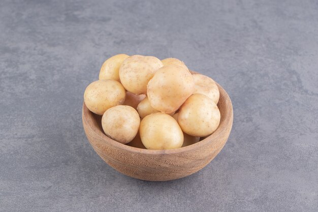 A bowl of ripe potato on the marble surface