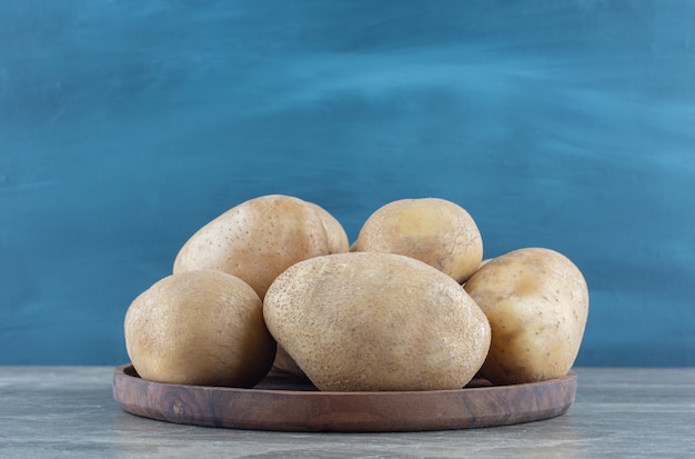 Free photo a bowl of ripe potato on the marble table.