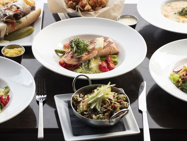 Bowl of salmon fish with vegetables on a wooden surface