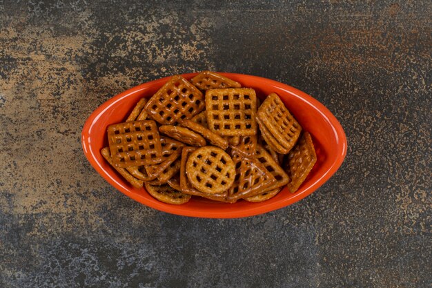 Bowl of salted crackers on marble.