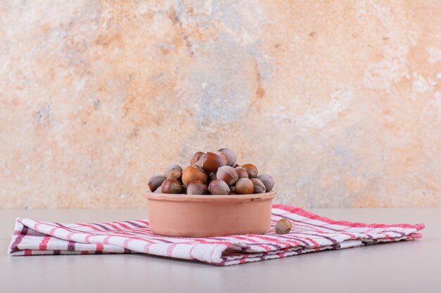 Bowl of shelled organic hazelnuts placed on white background. High quality photo