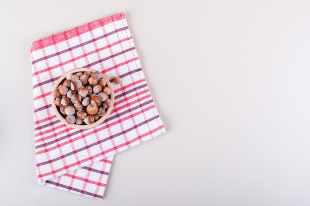 Bowl of shelled organic hazelnuts placed on white background. High quality photo