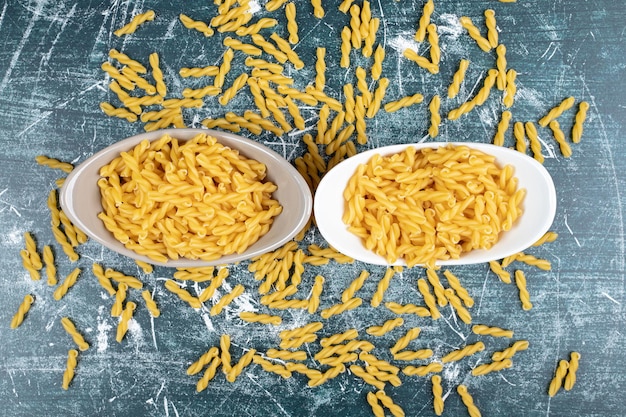 Bowl of spiral pasta on blue space. 