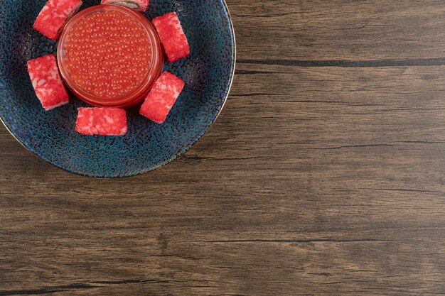 木製のテーブルに巻き寿司と赤キャビアのボウル
