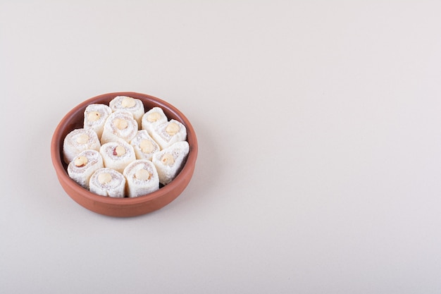 Чаша сладкого десерта лукум с орехами на белом фоне. Фото высокого качества