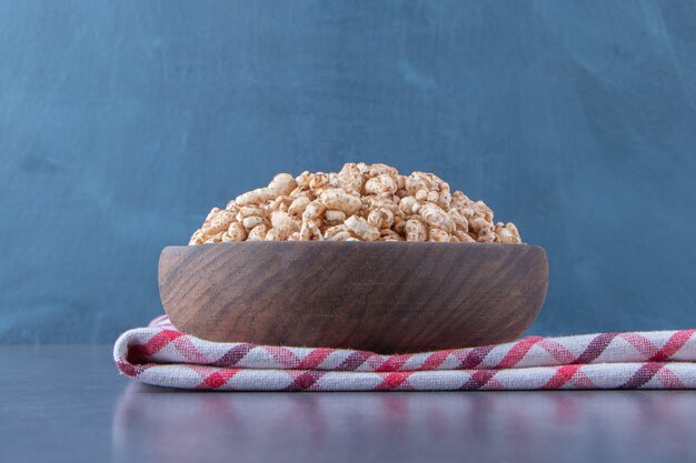 Foto gratuita una ciotola di muesli dolce su un canovaccio, sul tavolo di marmo.