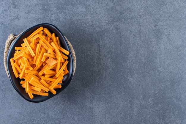 A bowl of sweet potato fries on trivet on the marble surface