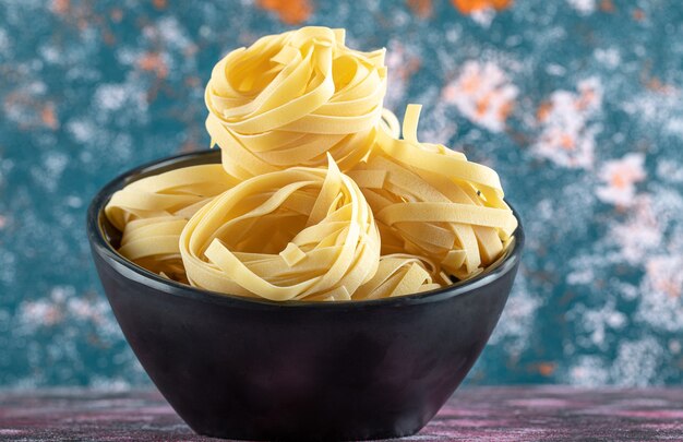 Ciotola di nidi di tagliatelle su sfondo colorato. foto di alta qualità