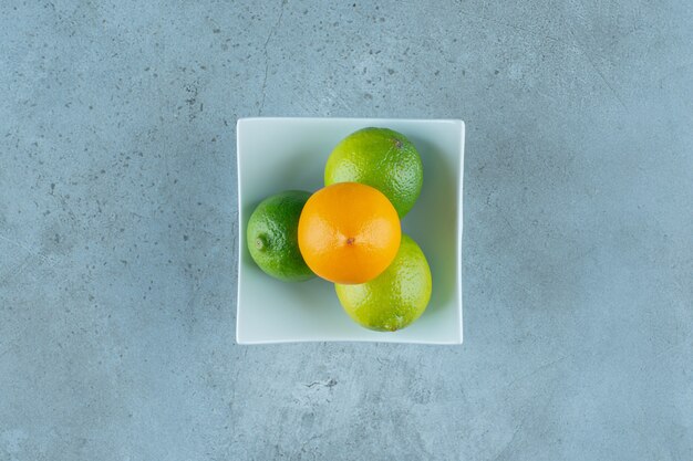 A bowl of tasty lemons , on the marble background. High quality photo