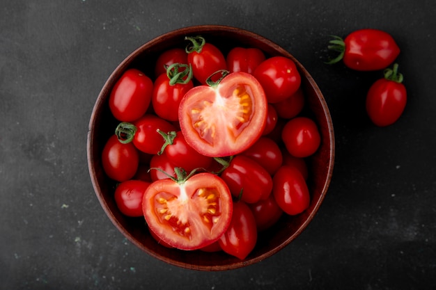 Foto gratuita ciotola di pomodori su superficie nera