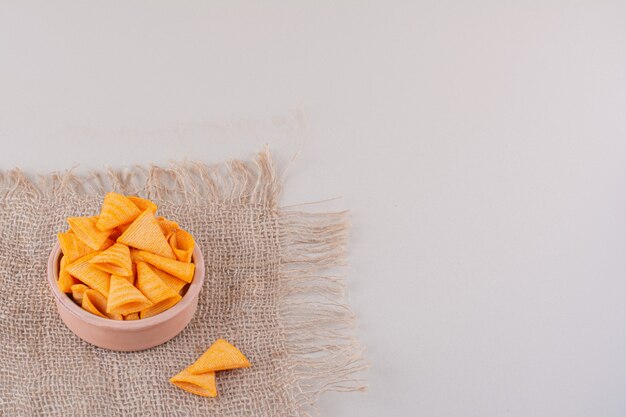 Bowl of triangle crispy chips placed on marble background. High quality photo