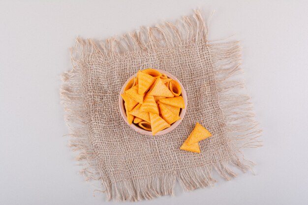 Bowl of triangle crispy chips placed on marble background. High quality photo